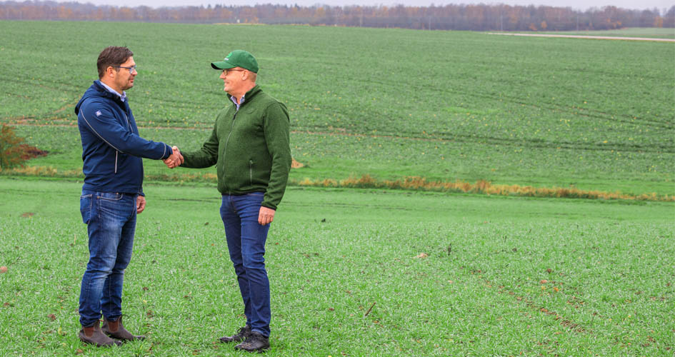 Yara and Lantmannen representatives shaking hands on a farm.jpg